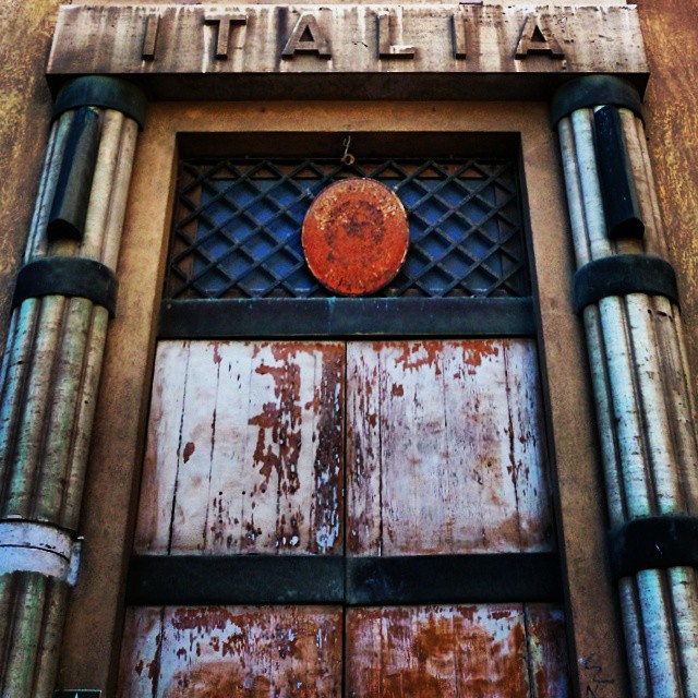 a rusty door with iron bars and an orange frisbee on the top