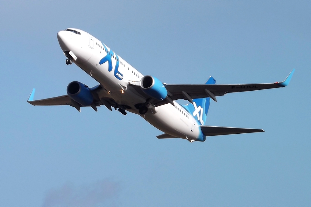 an airplane flies through a clear blue sky