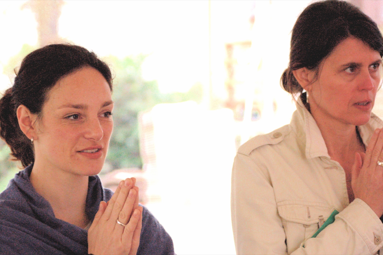 two women clapping as the woman watches them