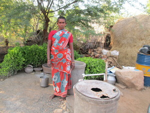 there is a woman standing next to several barrels and plants