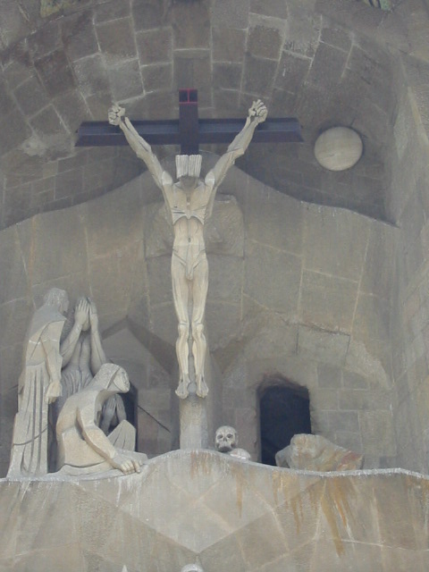 a religious statue of jesus is at the base of a crucifix
