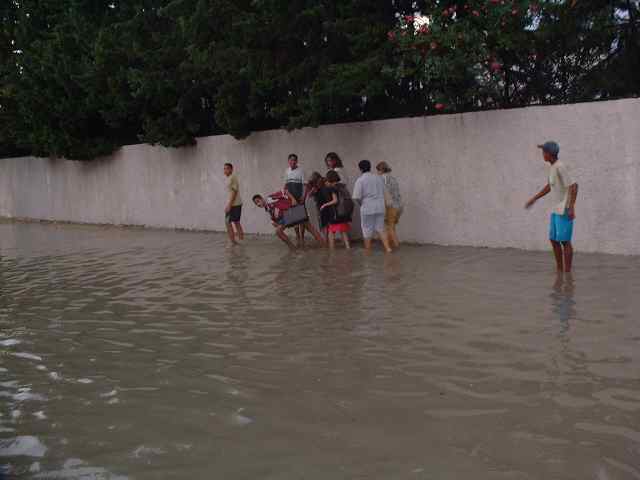 people standing around with a man walking on the sidewalk