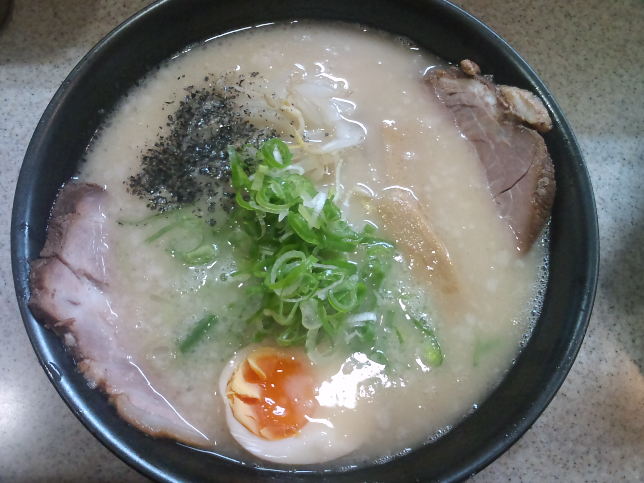 a bowl of ramen with meat, egg and vegetables