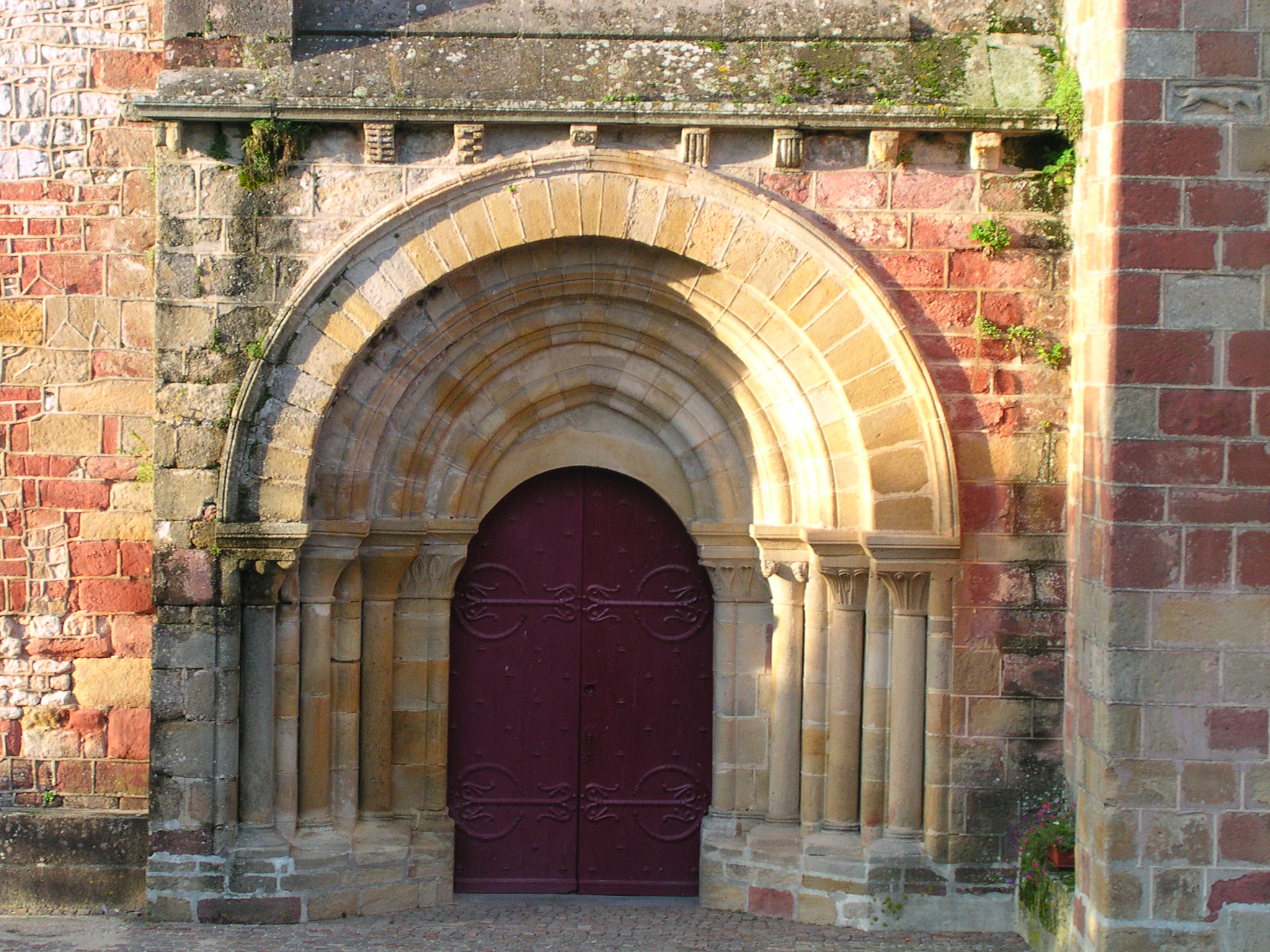 a stone and brick archway above a purple door