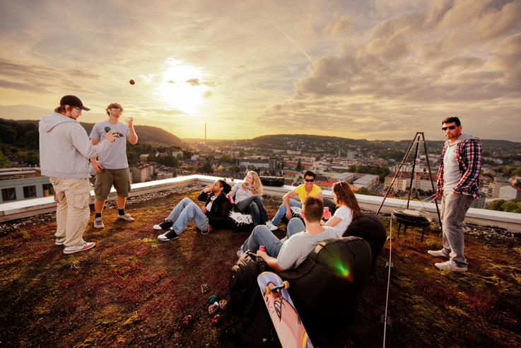 several men talking on top of the roof of a building