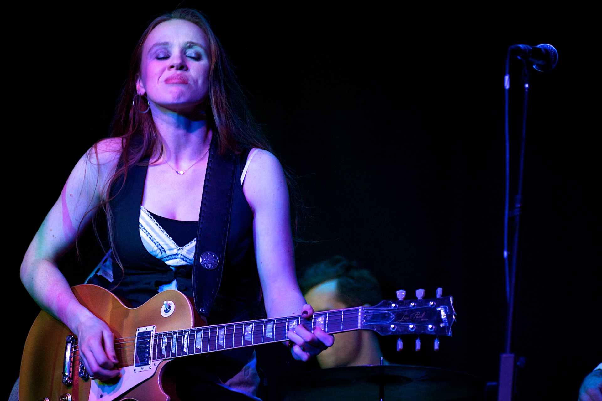 a girl playing an electric guitar while singing
