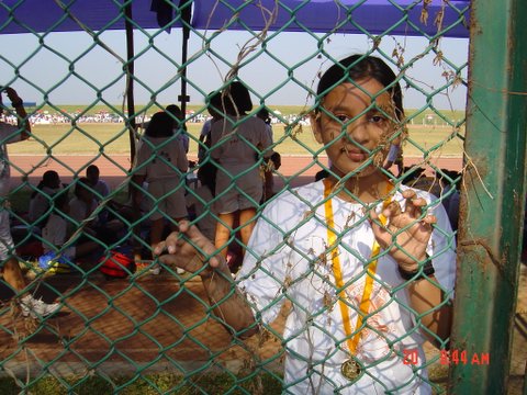 a girl in white dress looking through a gate