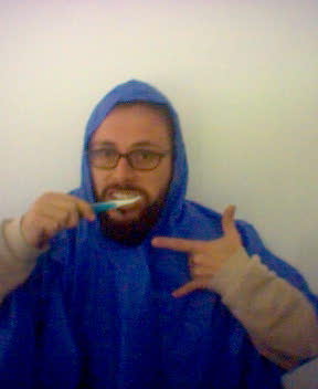a man with glasses and a blue cover is brushing his teeth