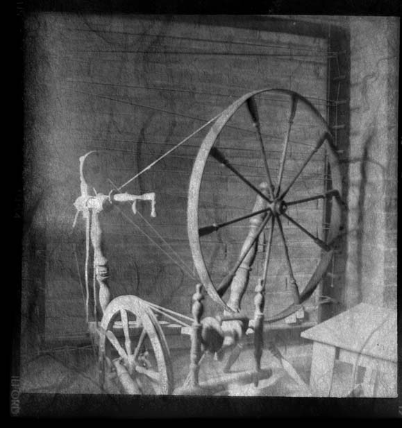 an old spinning wheel with other things hanging off it