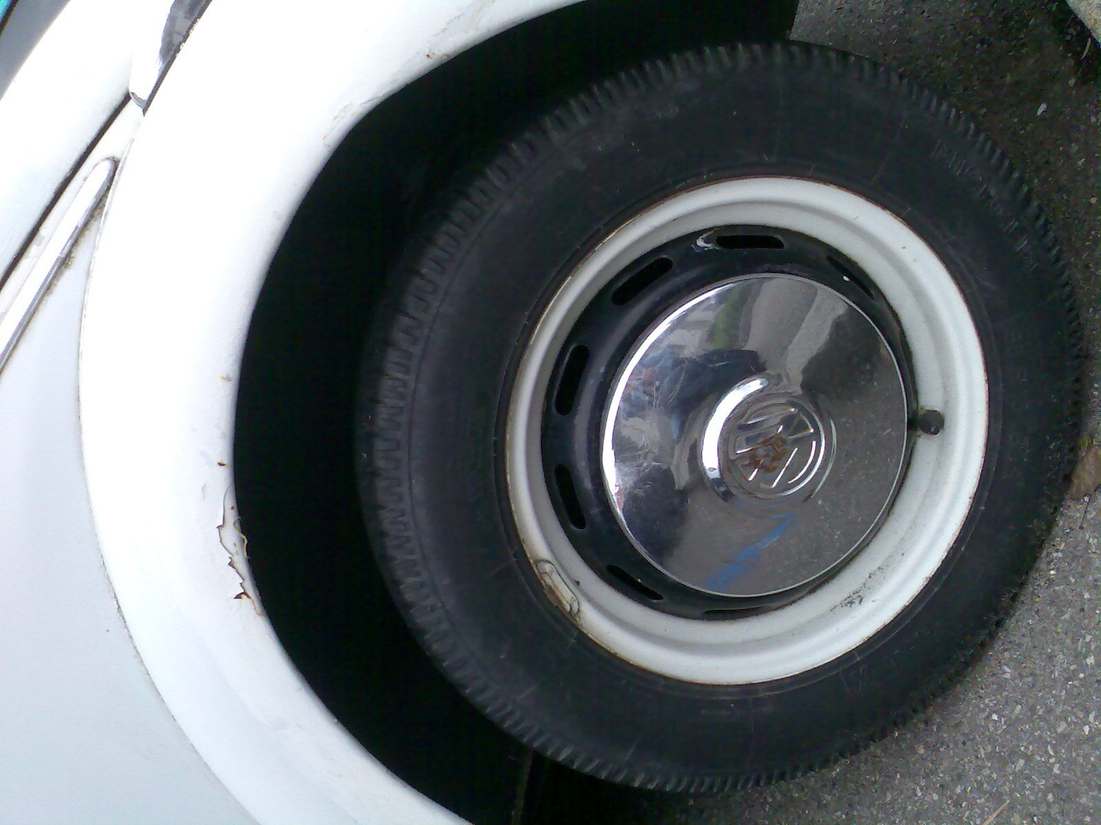 a small wheel sits on top of a white car