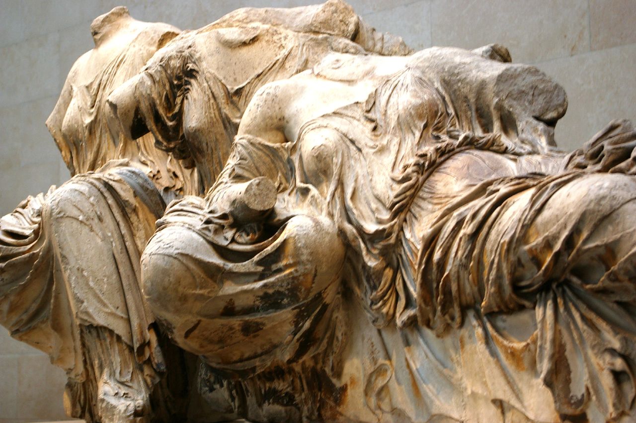 a close up of a statue of two people with dogs on their backs