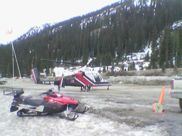 an helicopter is parked outside next to a sled