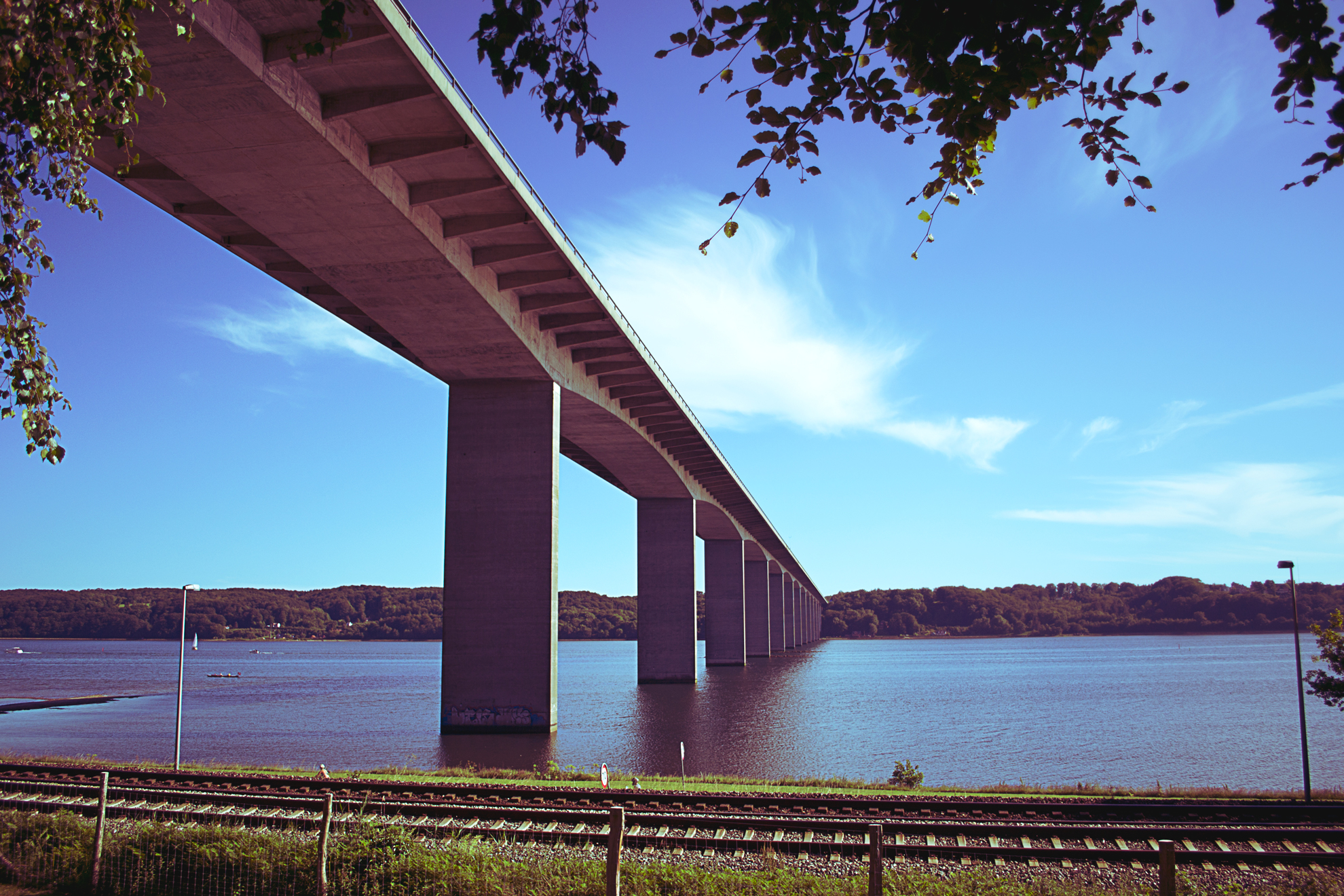 train track and road tracks under a bridge