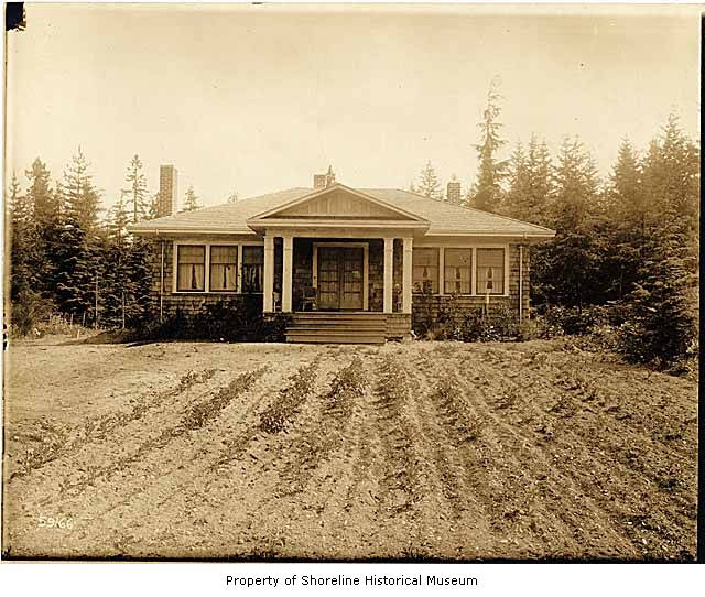 a house sitting on top of a hill next to trees