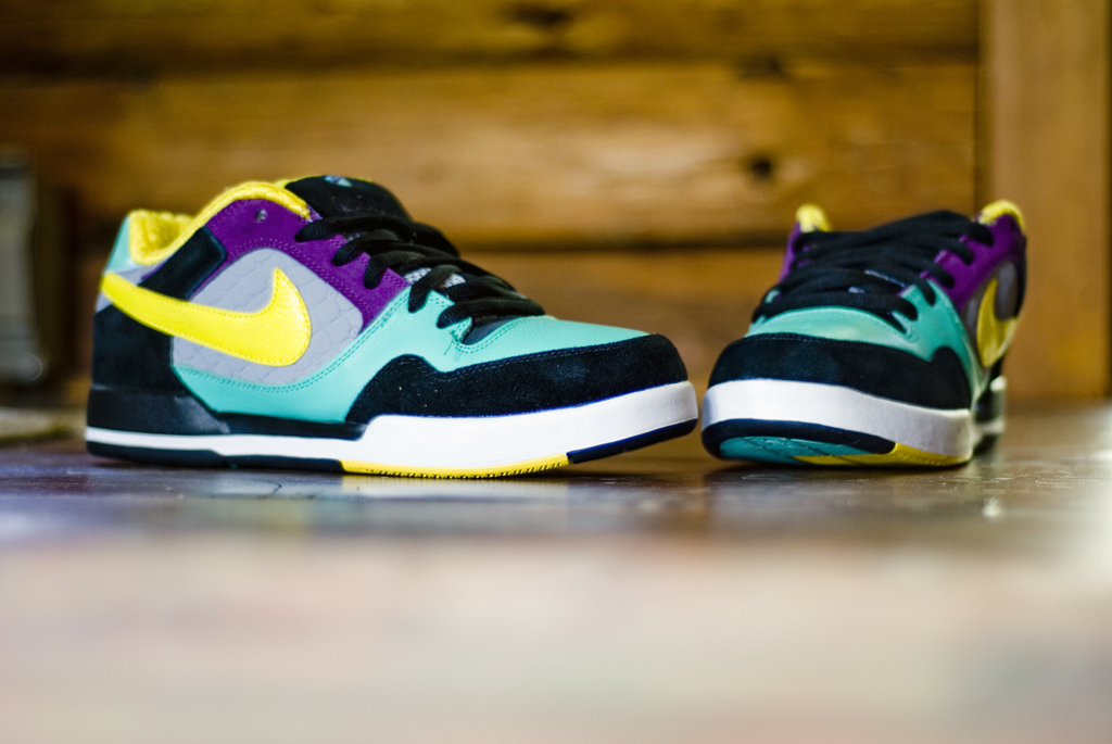 a pair of colorful sneakers is pictured in front of a wooden wall