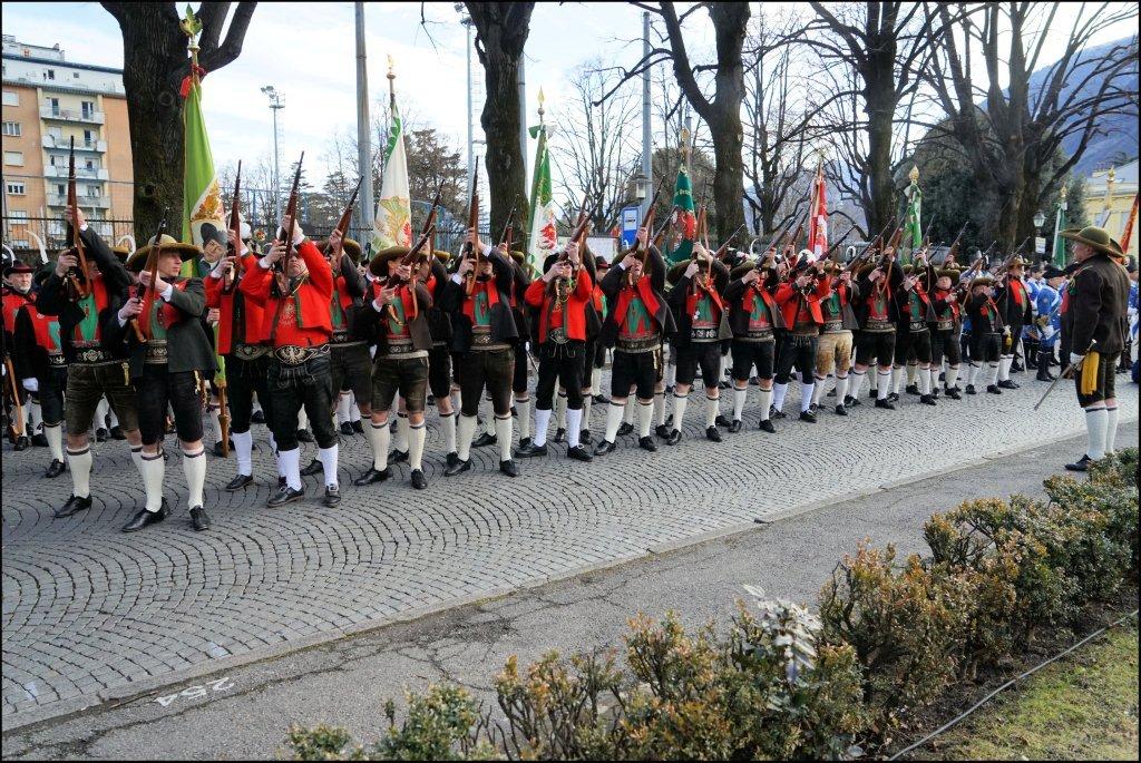 many people in red vests marching on the road