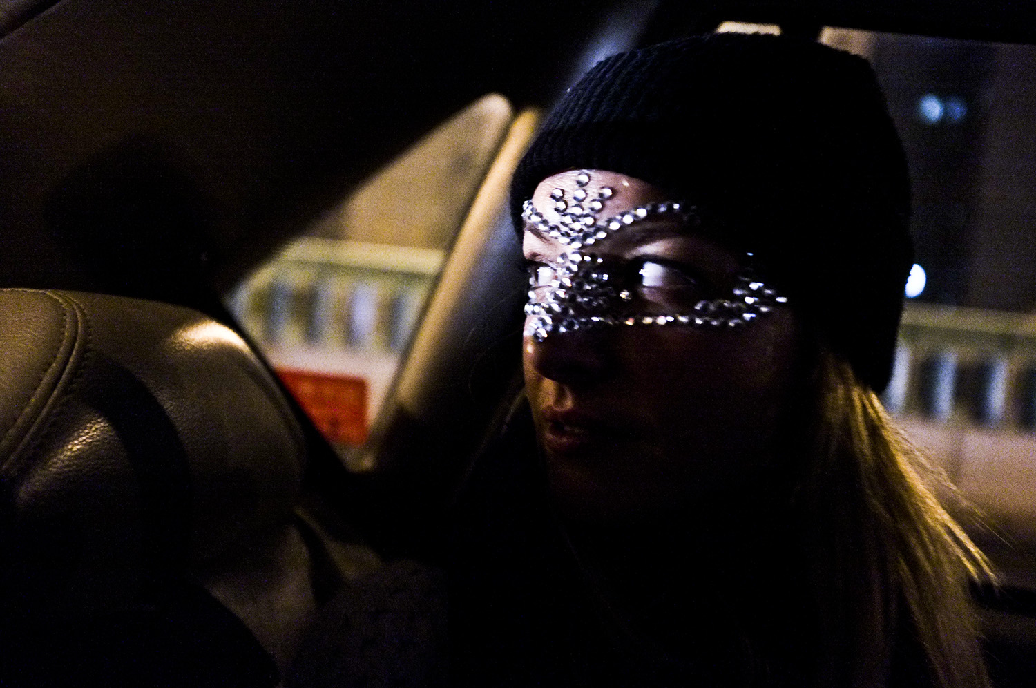 a person with silver beading on their face in a car