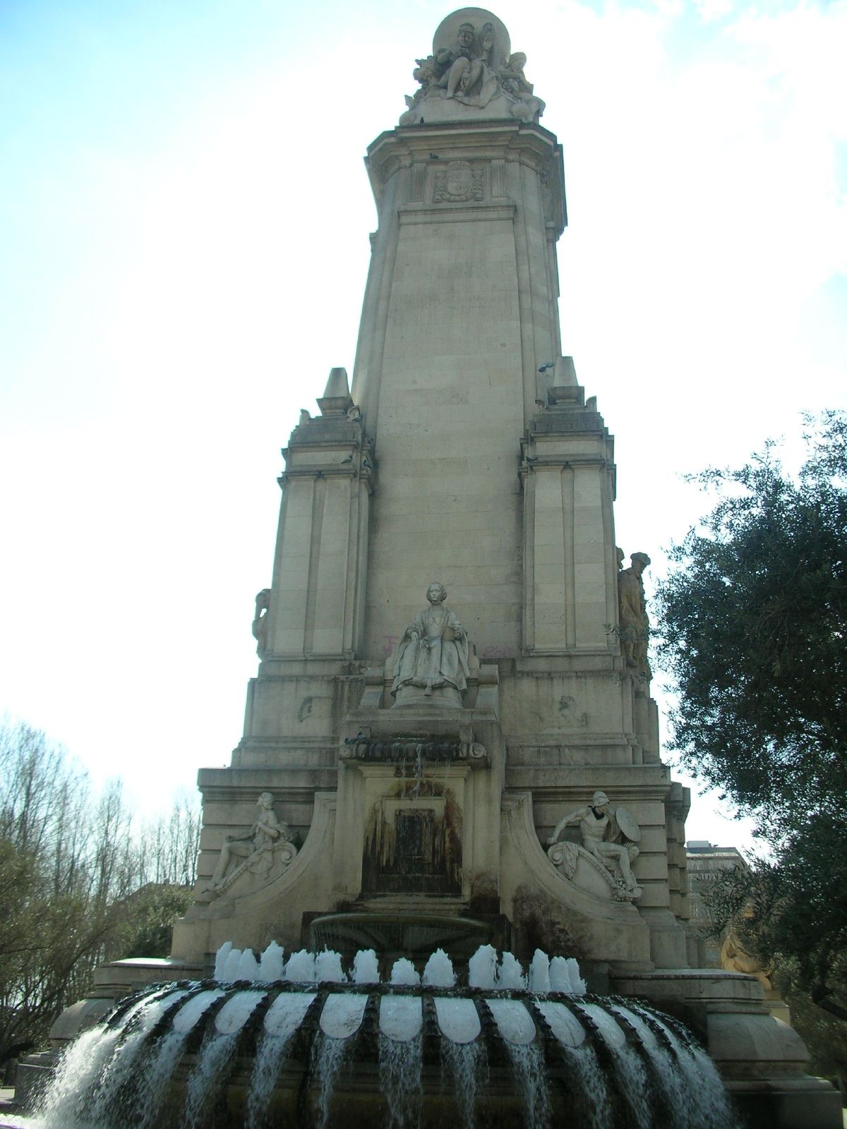 a large stone statue with fountain below it