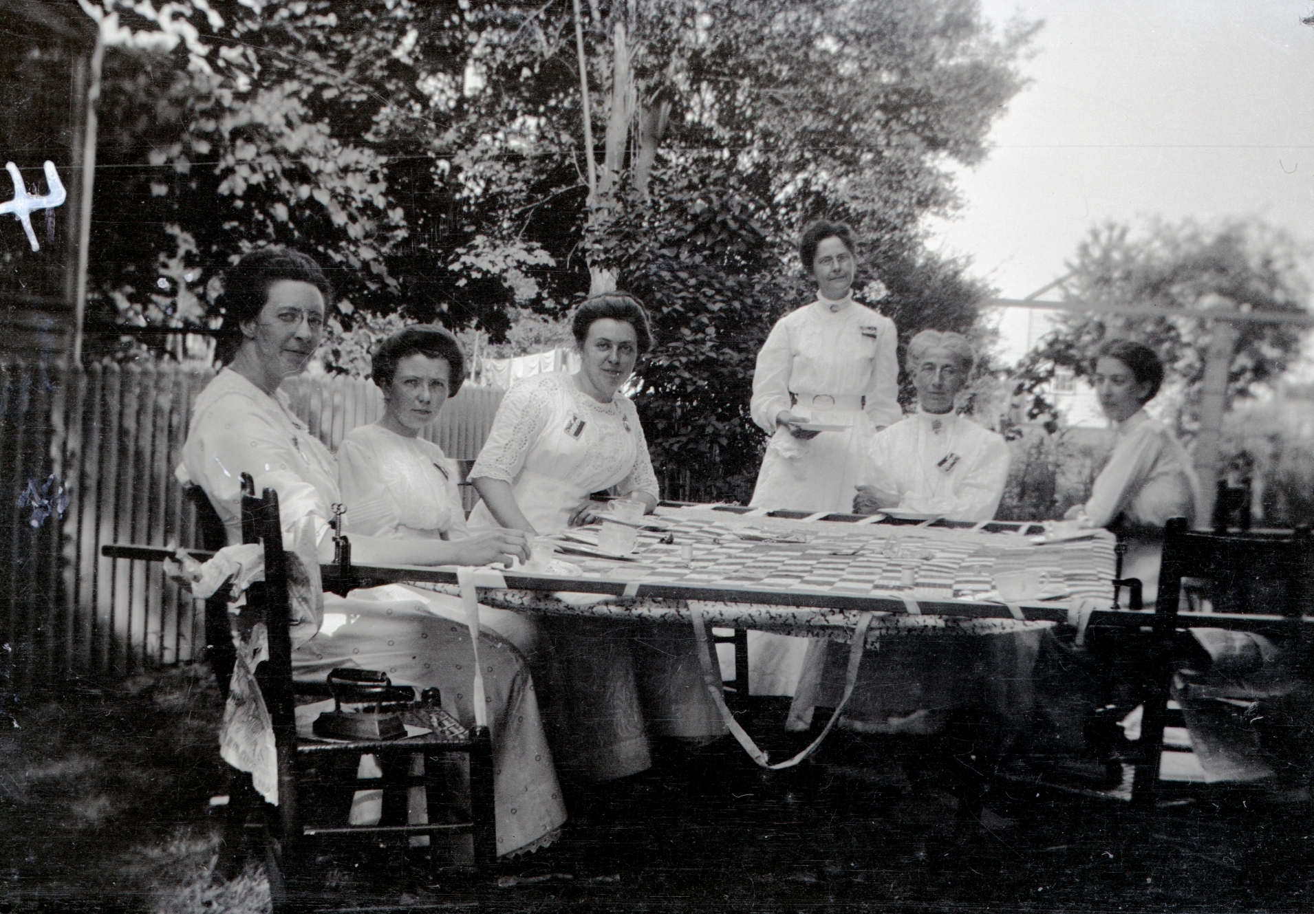 a family sitting down for a meal on a table outside