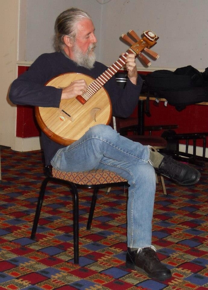 a man with a beard plays the instrument