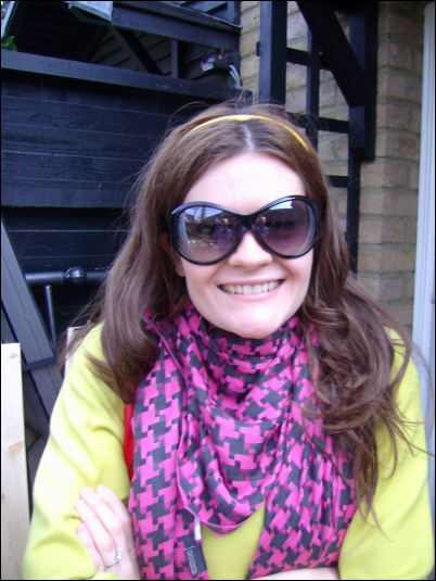 a smiling woman wearing shades is posing for a picture