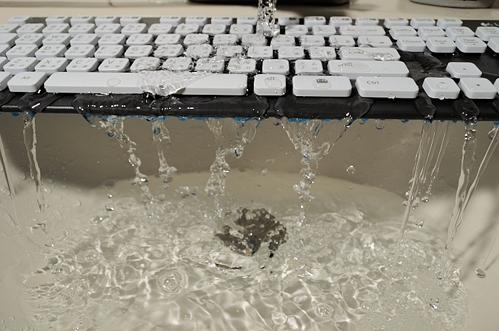 a computer keyboard covered in water as it is being cleaned