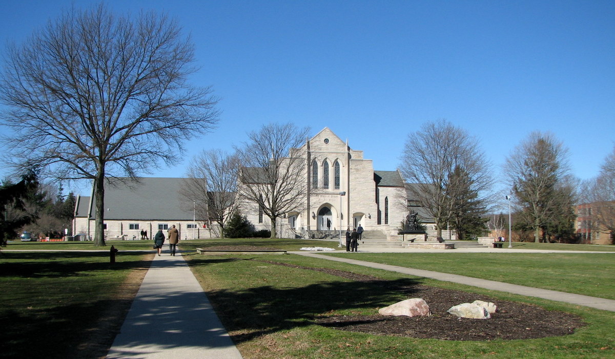 a church sits in front of a grassy lawn