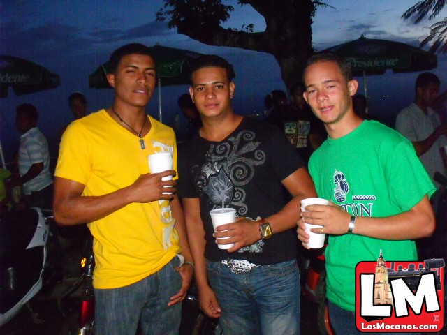 three young men are standing together with their drinks