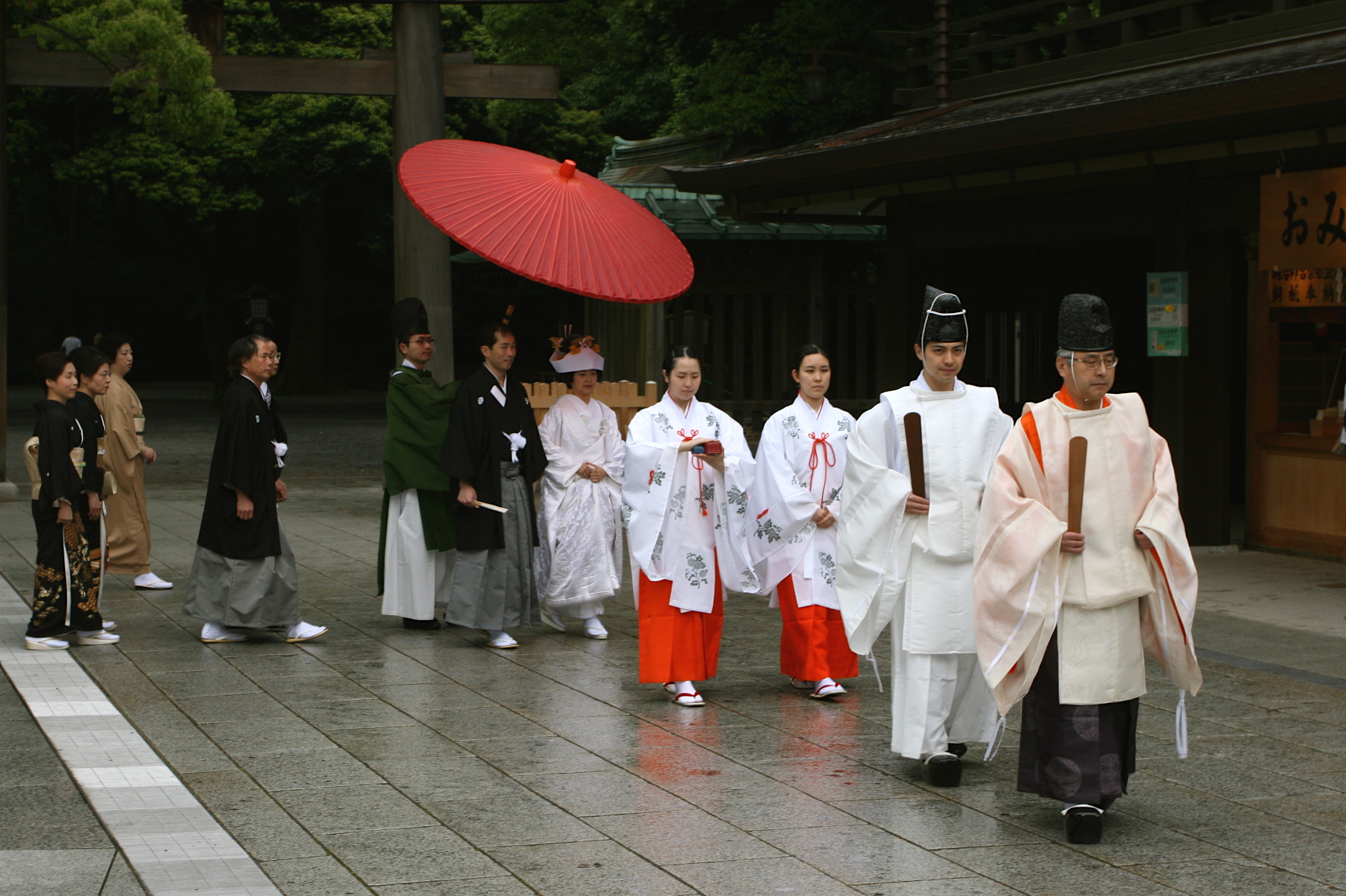 a group of men dressed in kimono walk down a stone pavement