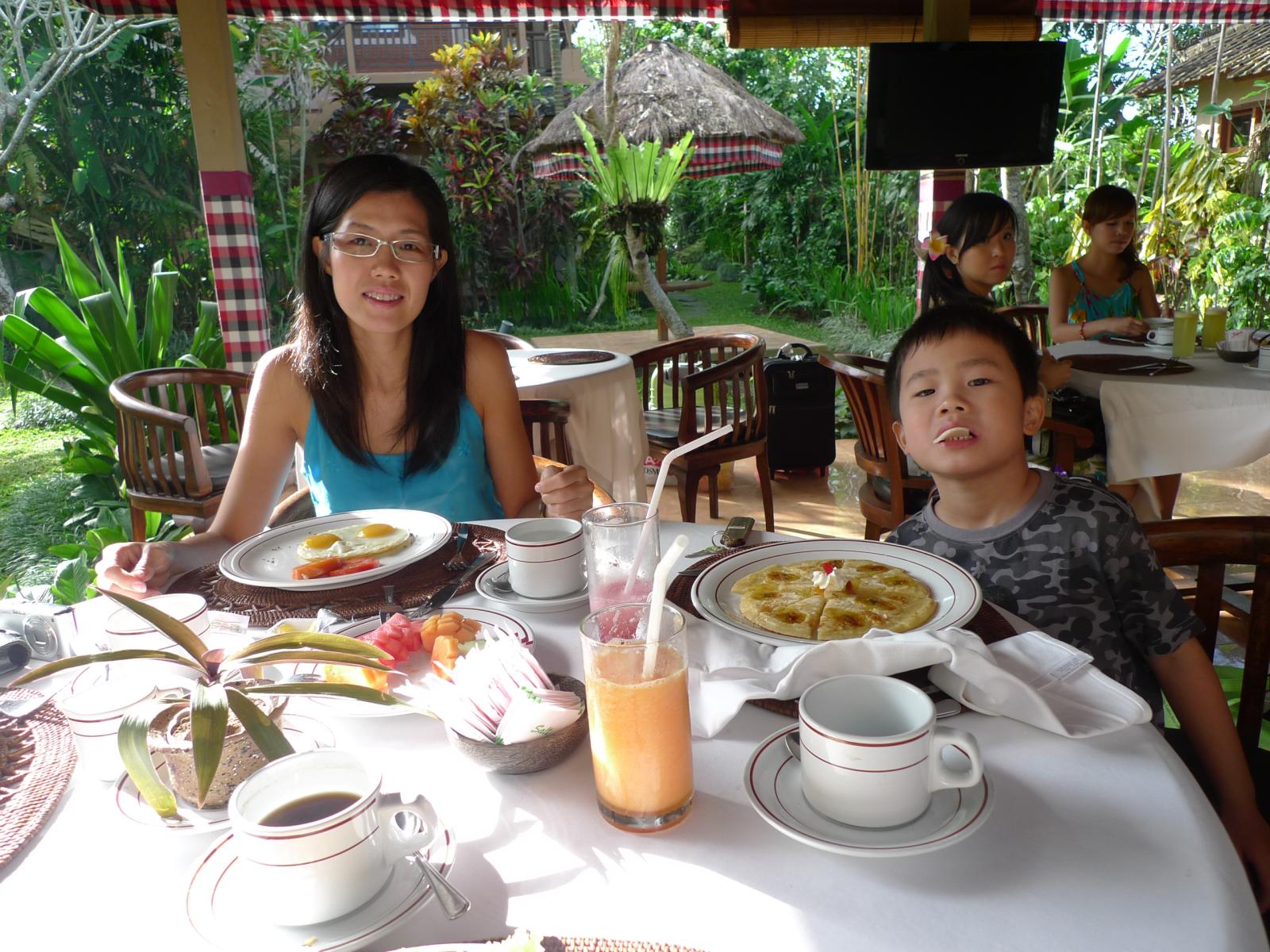 a woman and a child sitting at a table with food