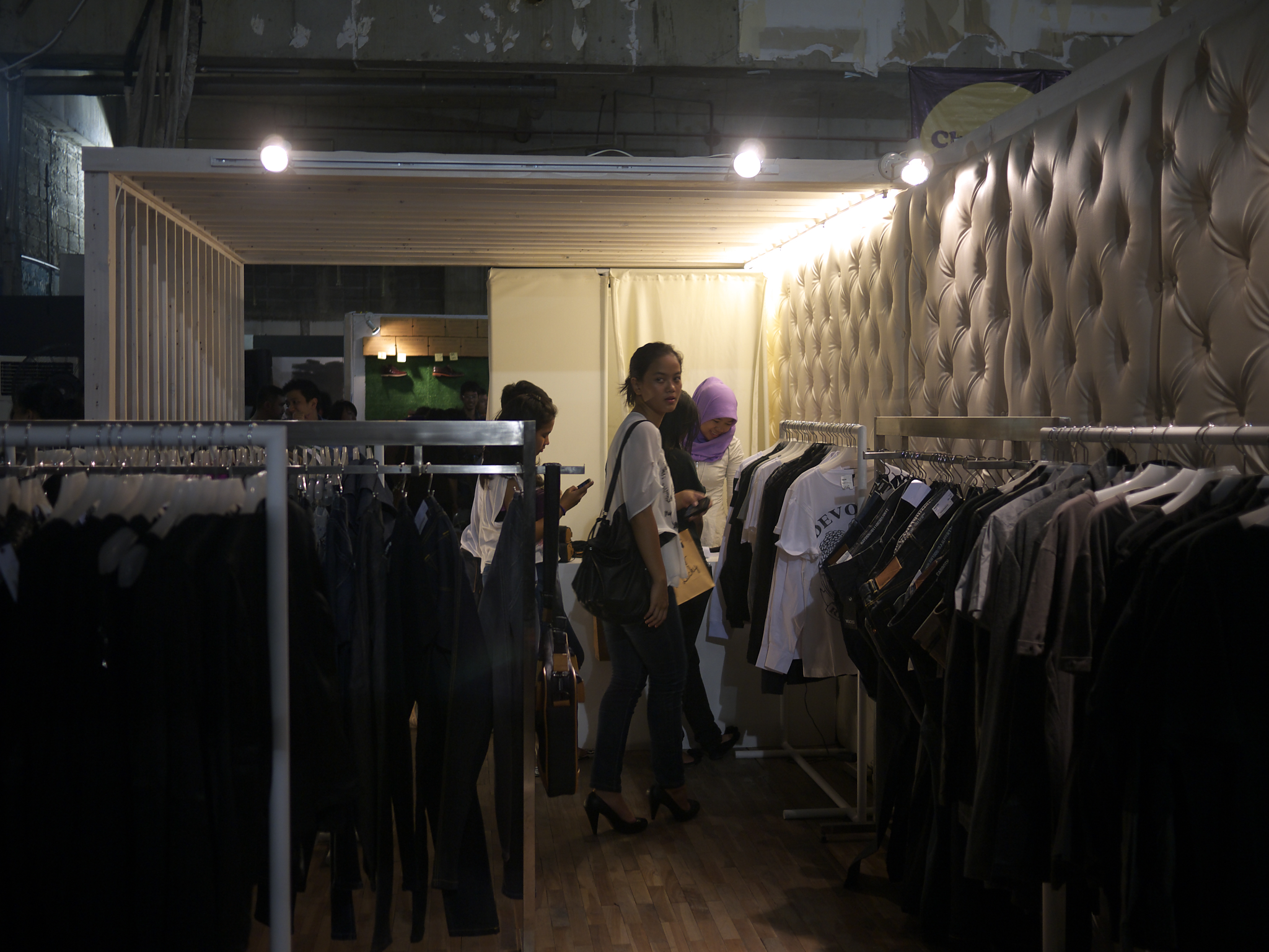 a couple of people standing in front of a clothing rack