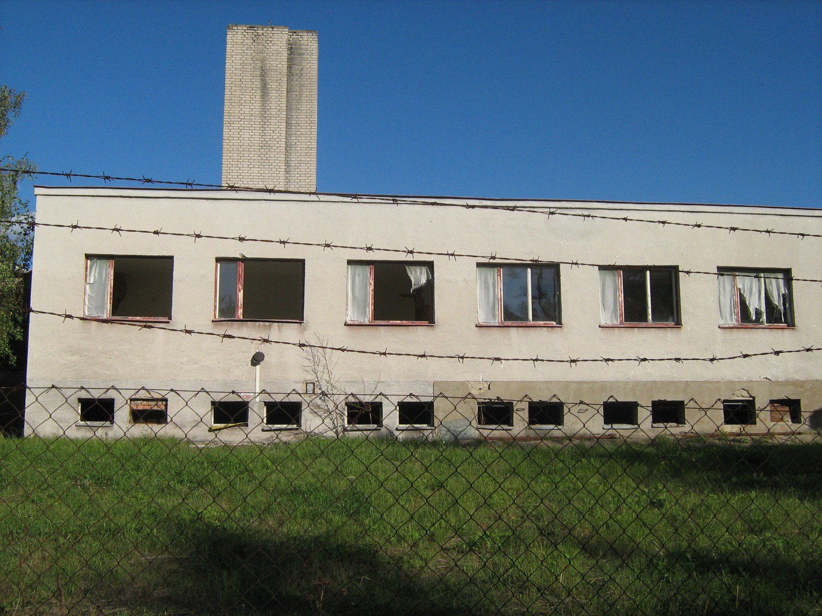 a white building with two chimneys and several windows