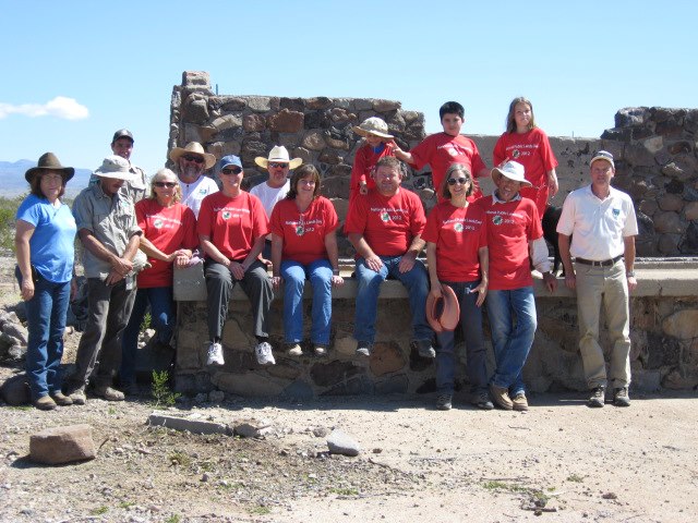 some people standing around while wearing red shirts