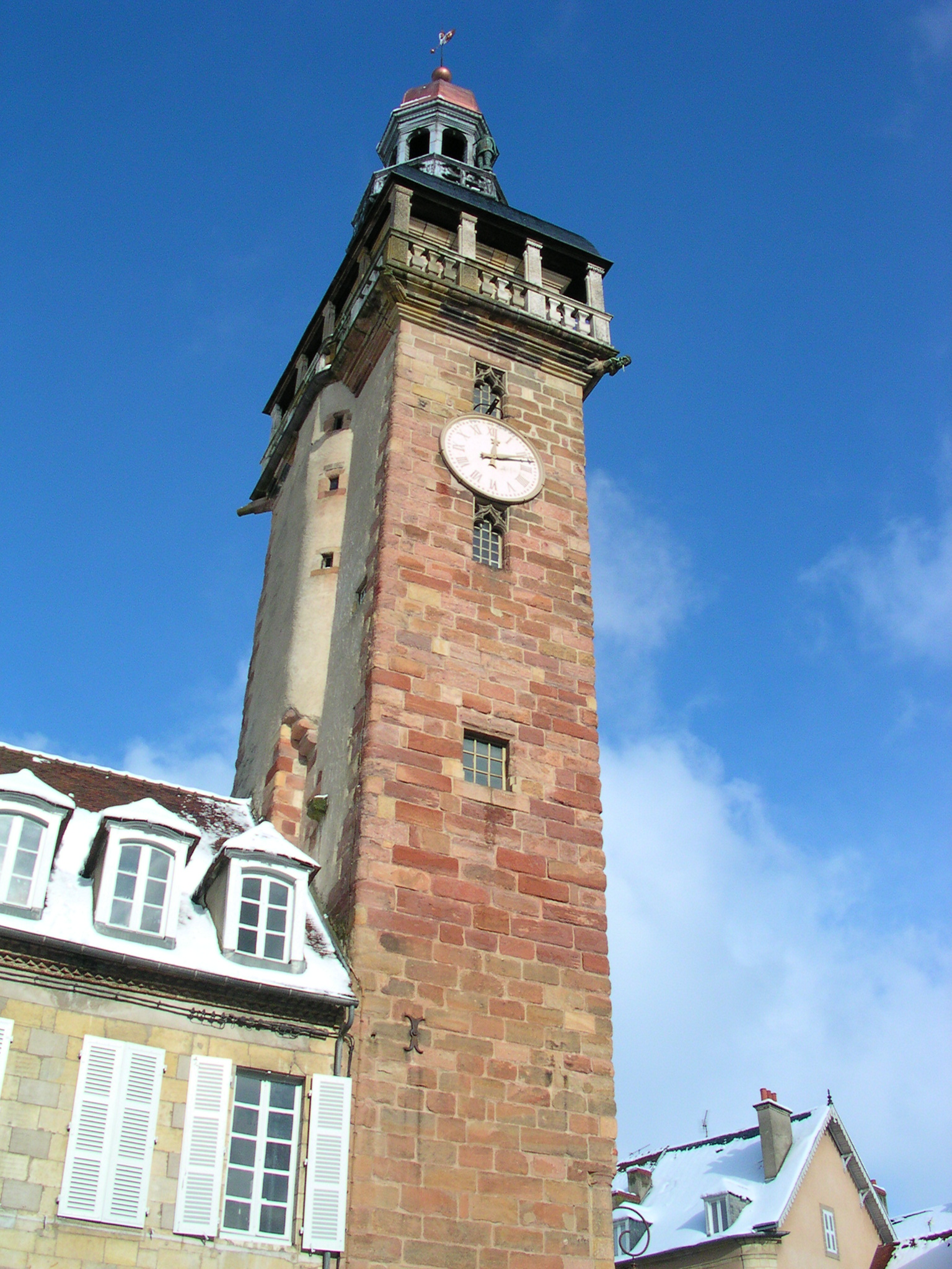 a clock tower with white shutters on a sunny day