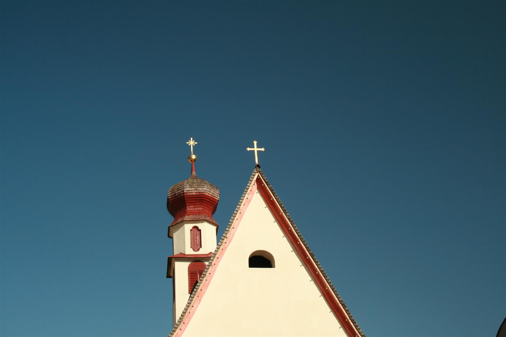 the top of an old church with a steeple and cross
