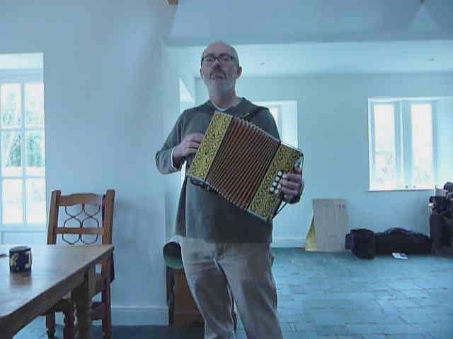 an older man holding up a weird looking accordion