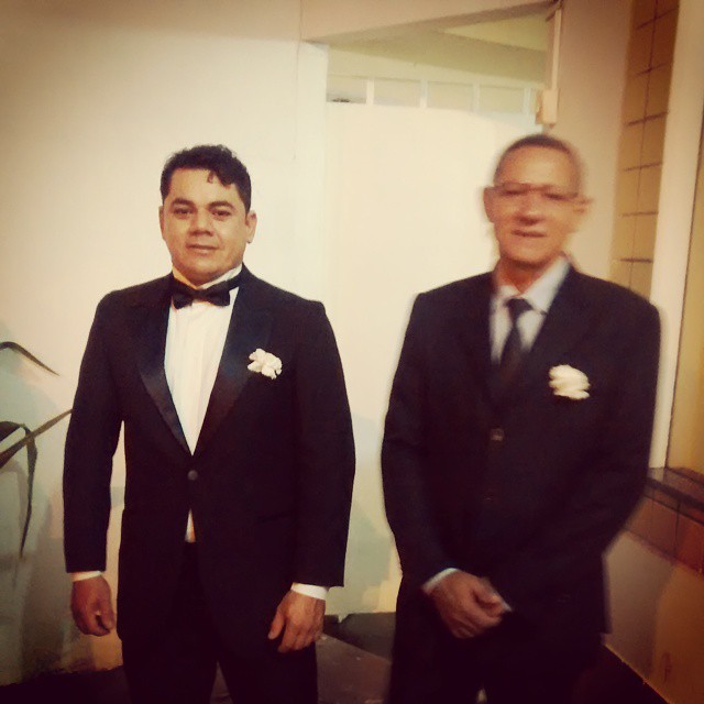 two gentlemen are in formal wear standing together