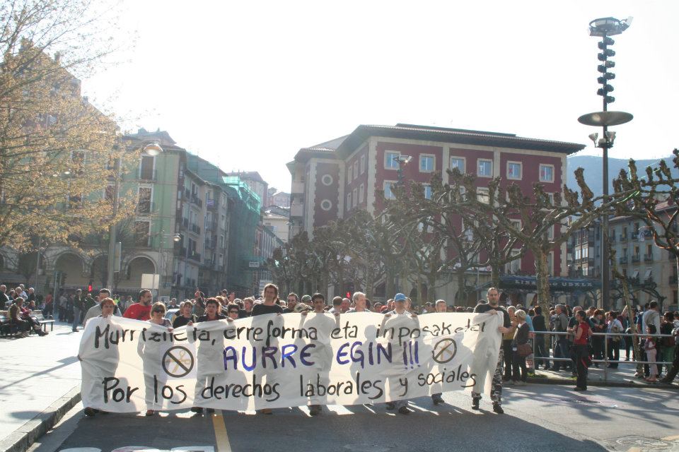 many people holding up signs in front of buildings