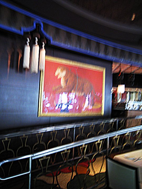 a painting hangs on a wall above a bar