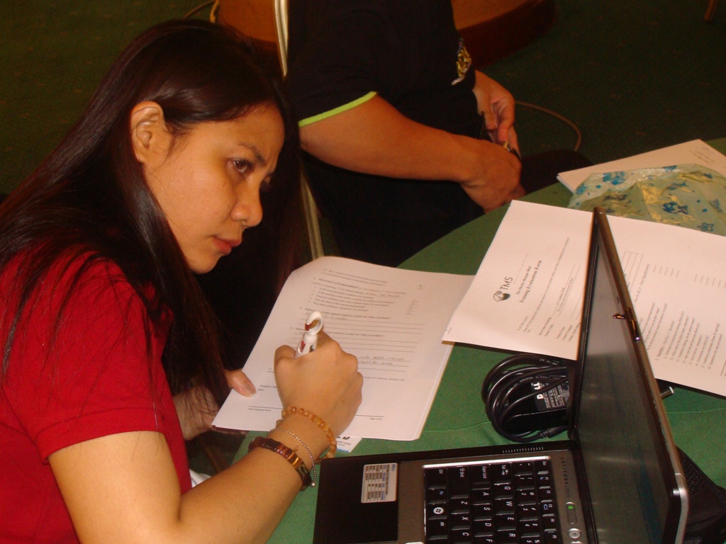 a woman writes soing on her paper at the table