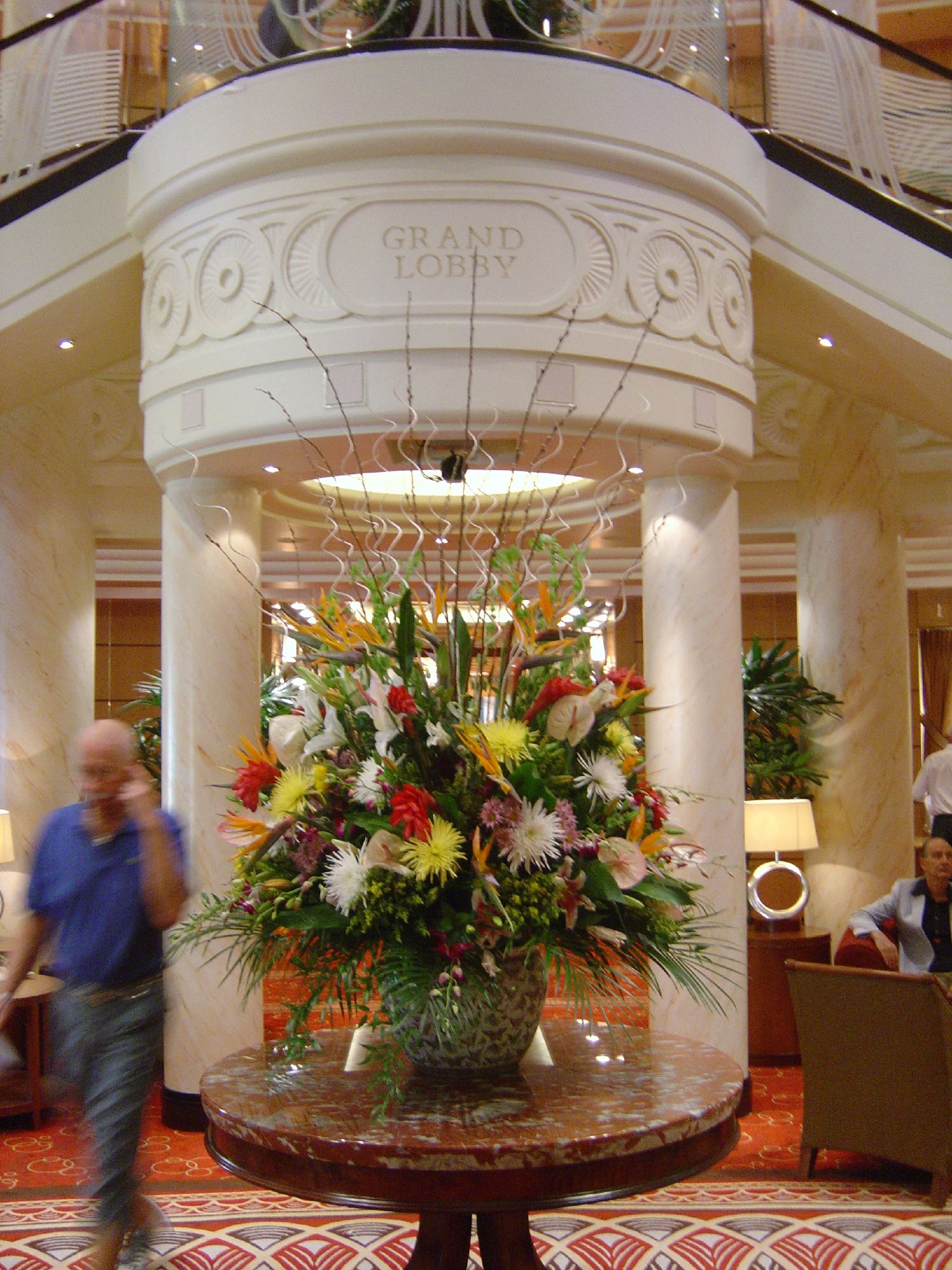 a vase of flowers on a table with people inside