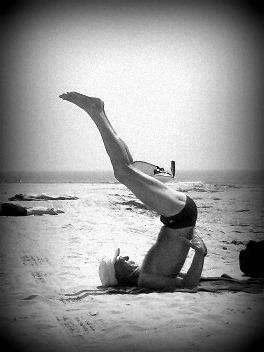 a man in a suit upside down on the beach