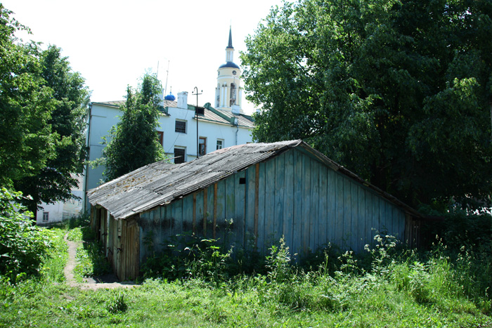 a barn sits near many trees and buildings