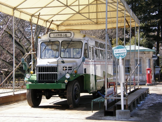 an old style bus is parked in front of the park shelter
