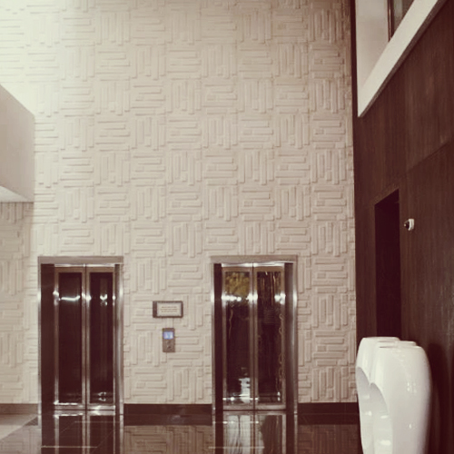 two urinals are next to an elevator in a building