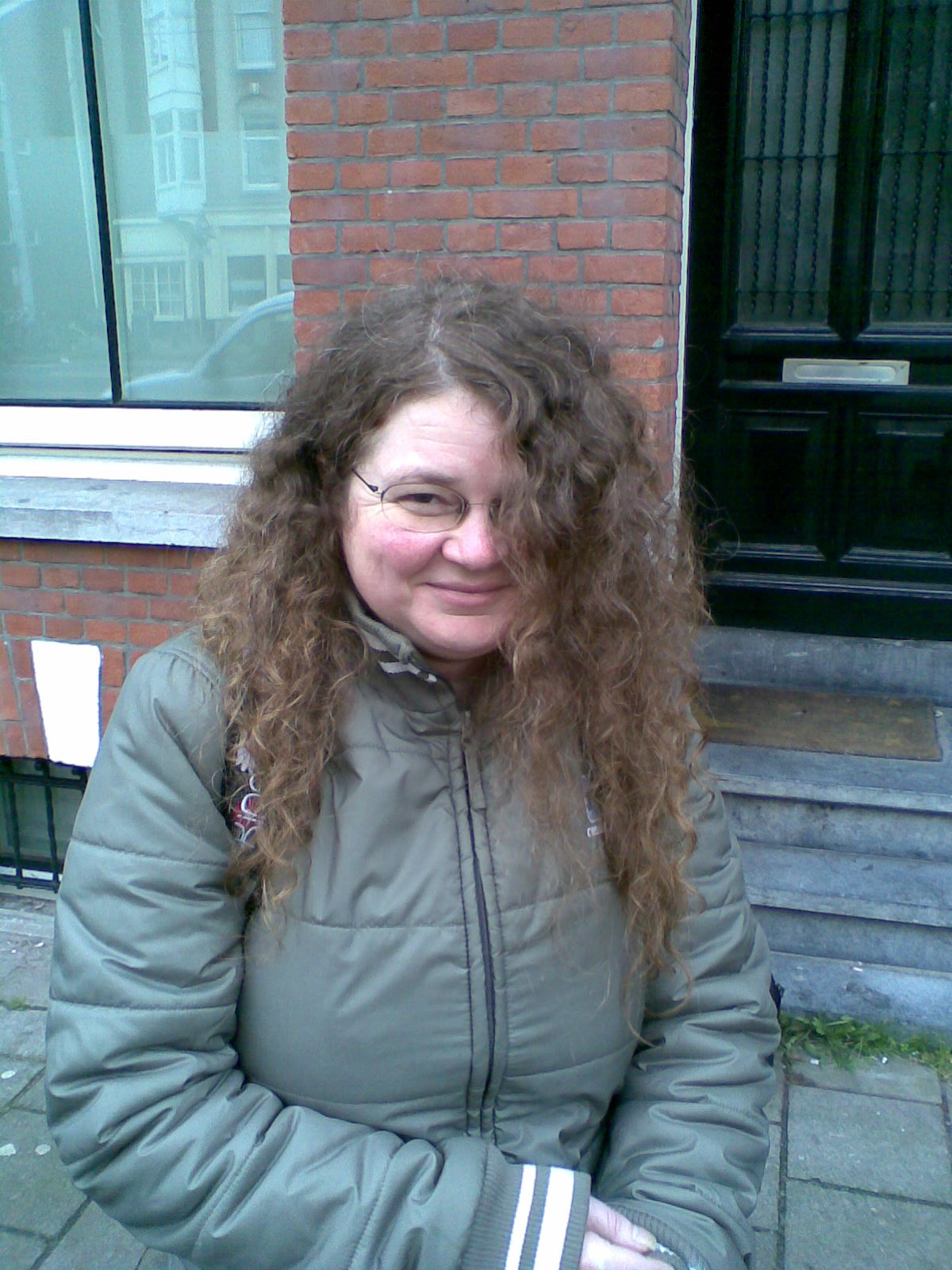 a lady that is sitting on the sidewalk