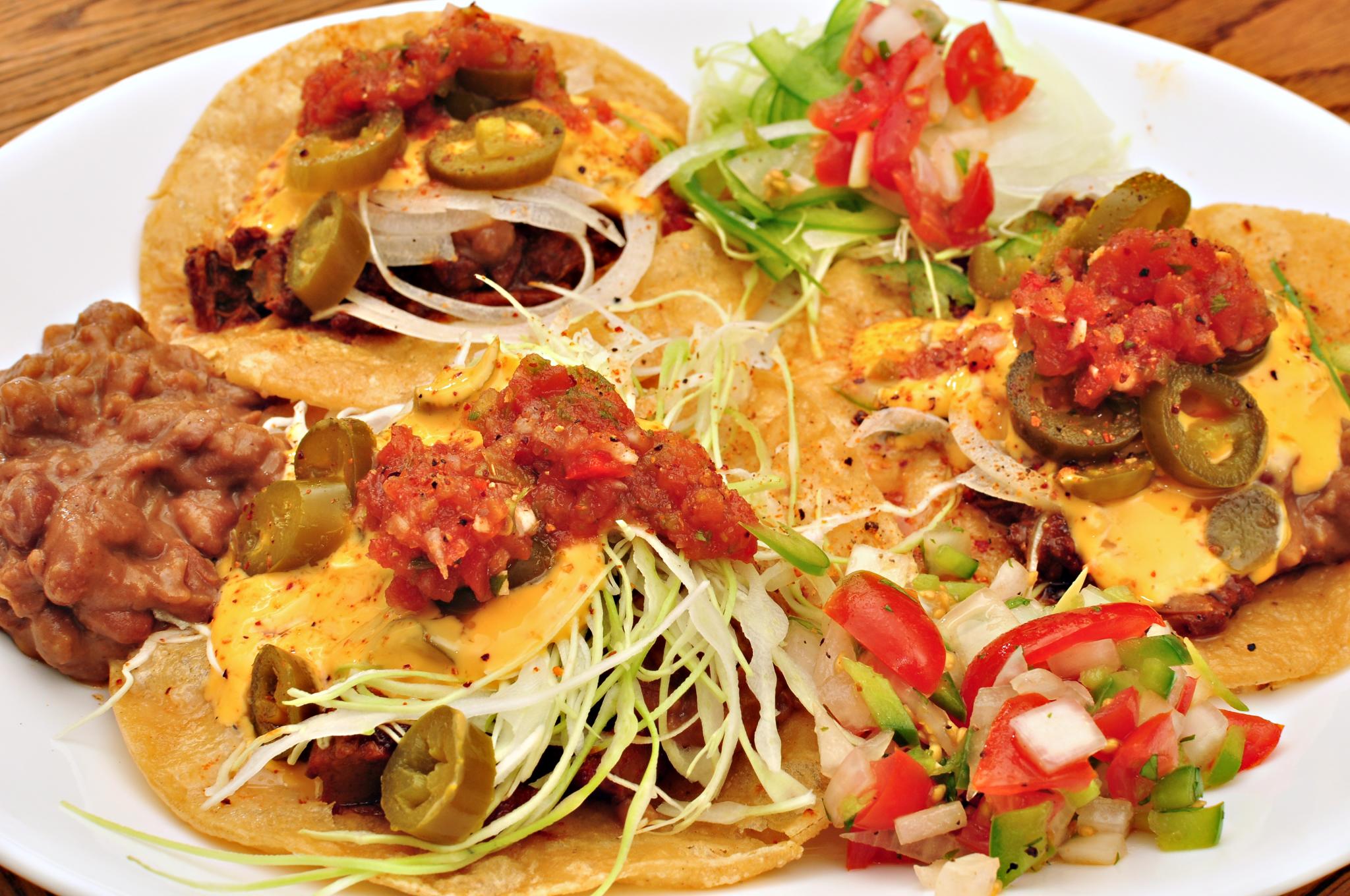 a plate of tacos and salsa on a wooden table