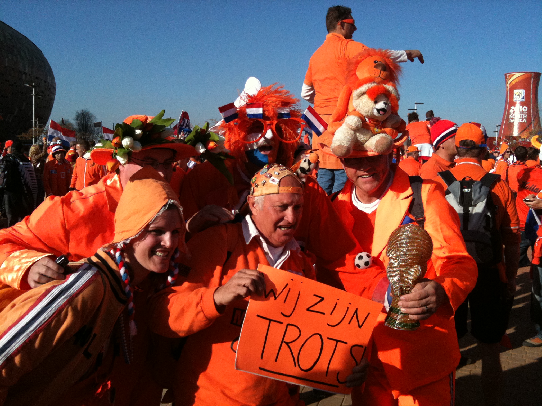several people dressed in orange holding signs at an event