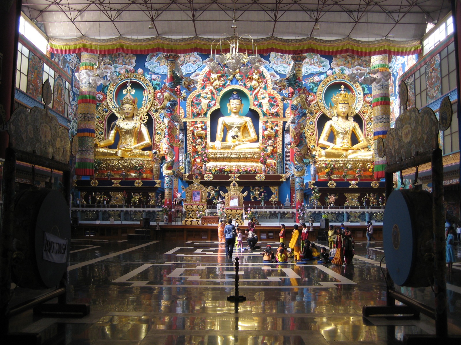 inside of an oriental building with many buddha statues