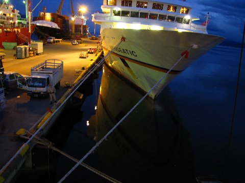 a large boat docked at a terminal at night